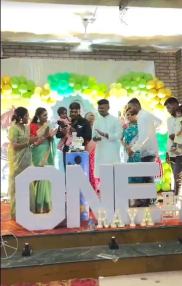 Family celebrating first birthday on decorated stage