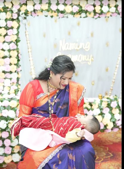 Mother holding baby at naming ceremony, Aarsh Event's decor